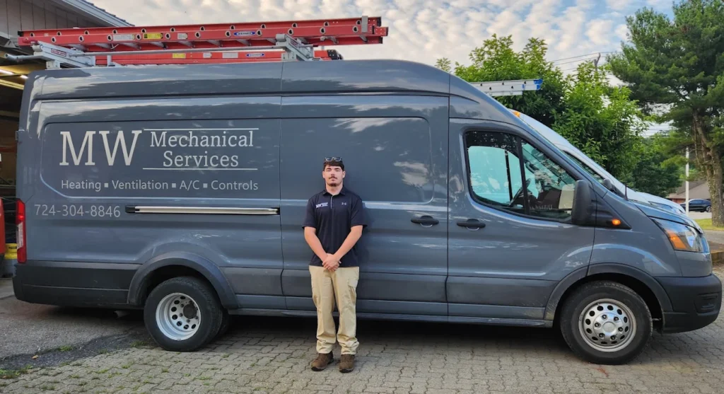 mw mechanical services team member standing in front of van